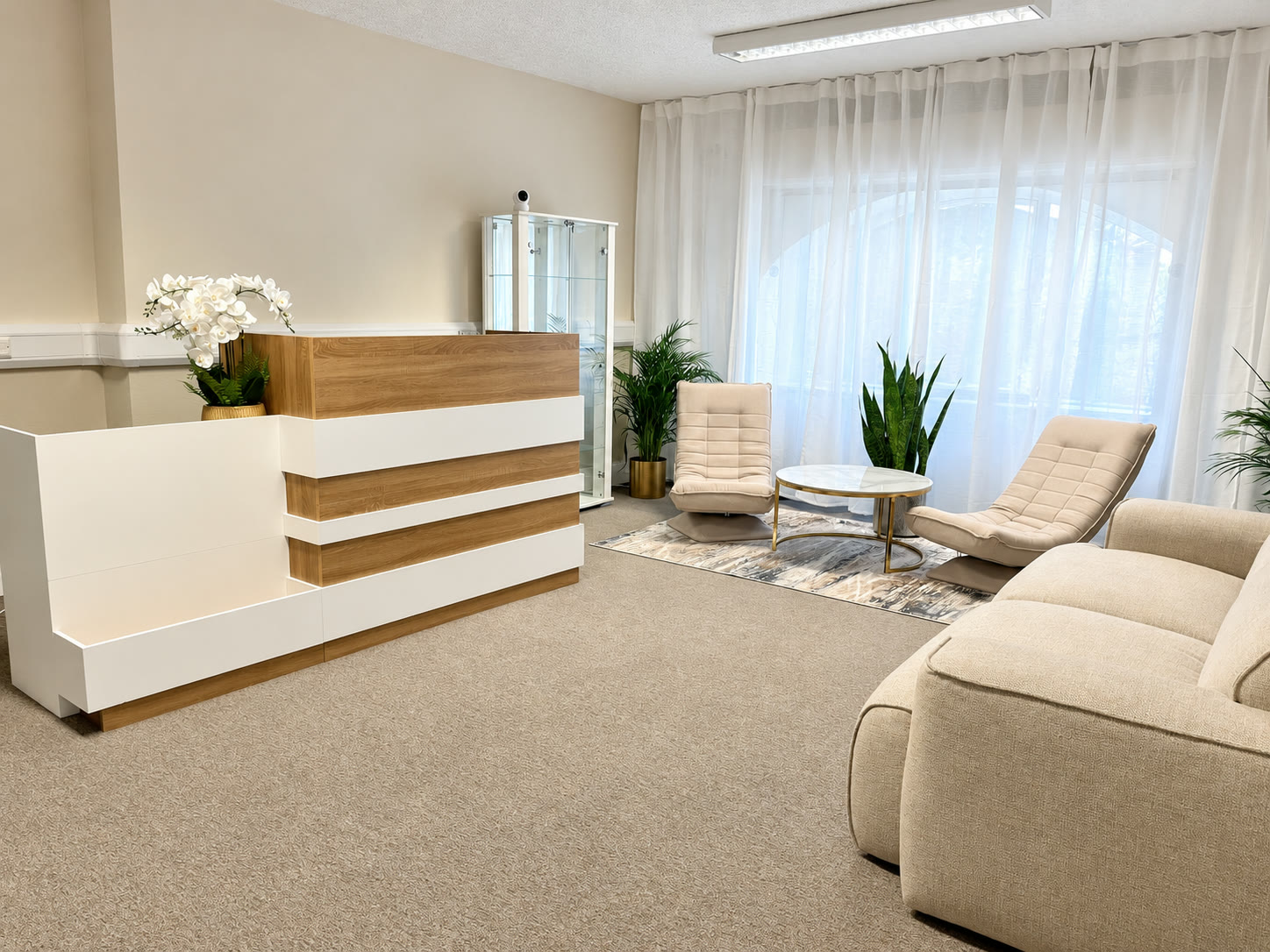 The white and oak reception desk with the lounge behind it