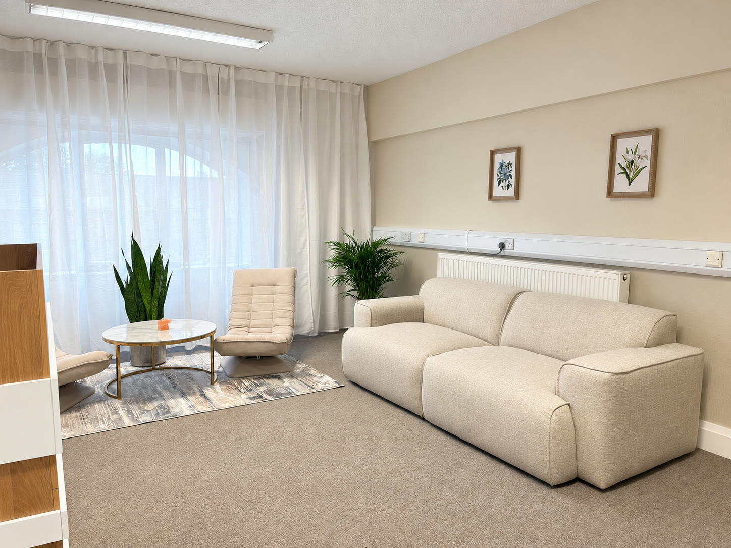 The reception lounge: cream sofa, chairs and plants in daylight