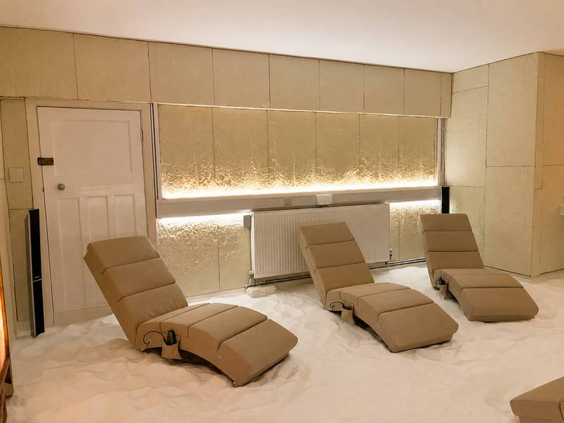 Four recliners on the white salt floor of the salt room